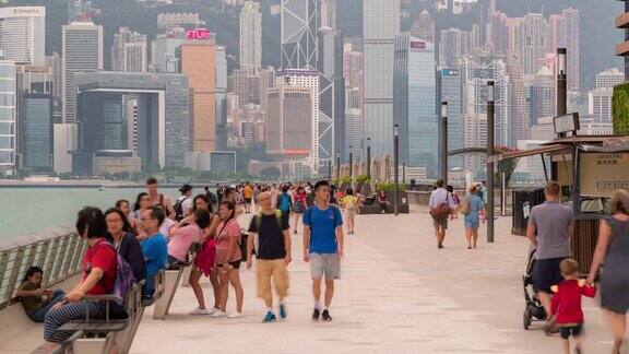 慢镜头:行人挤在星光大道上背景是香港市中心的