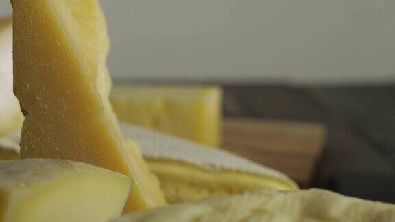桌上放着一片片的奶酪各种类型的奶酪布里干酪帕尔马干酪卡西奥塔干酪瑞士奶酪在慢动作中旋转