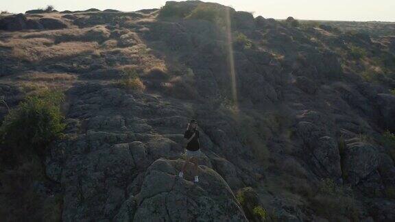 一个年轻美丽的女孩站在峡谷的悬崖边