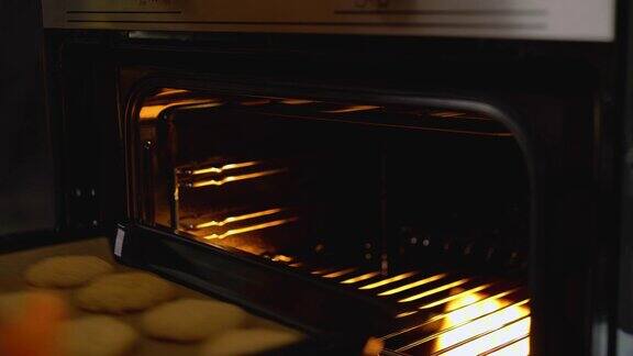 奶奶从热烤箱中取出盛着饼干的烤盘温馨的家的气氛