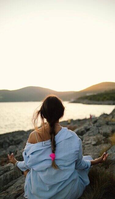 海边的一个年轻女子正在做瑜伽和冥想
