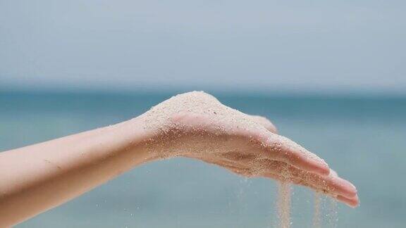女人吹掉手上的沙子沙子从手指间倾泻而出细沙从手掌中流过
