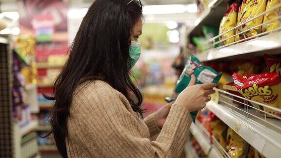 在超市货架上的亚洲年轻女子