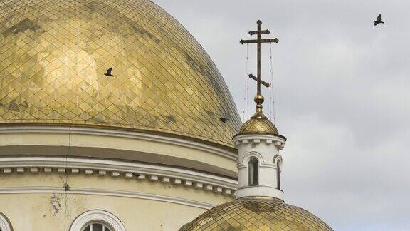 鸟飞近美丽的教堂宗教观念资料片在云彩的背景下东正教的金色十字架和教堂的圆顶