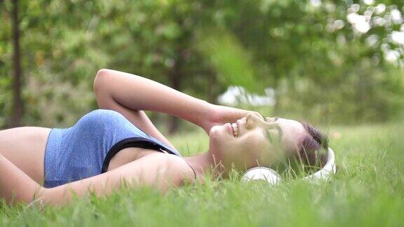 女人躺在草地上听着音乐放松哼着歌