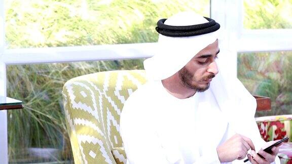 阿联酋阿拉伯人在咖啡店使用智能手机-4k