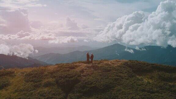 这对夫妇站在山顶上映衬着美丽的天空