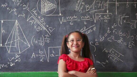 快乐的女孩在课堂上写黑板面带微笑