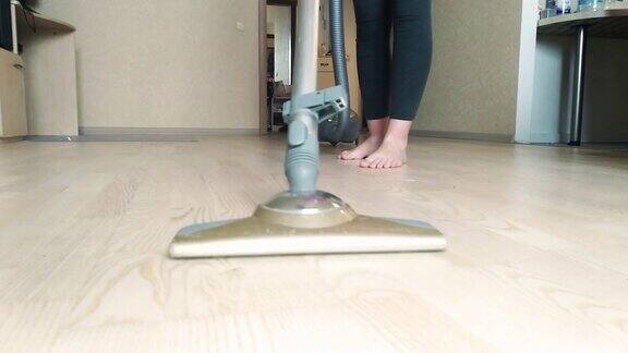 一位妇女用吸尘器清扫家里的地板