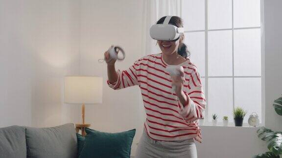 年轻女性戴上VR头戴设备在家中客厅体验动作模拟器舞蹈游戏手机app