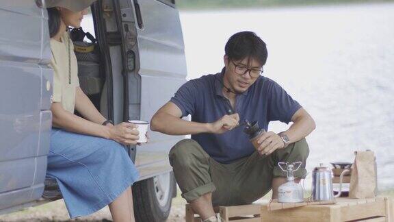 在湖边露营的时候年轻夫妇正在煮滴滤咖啡