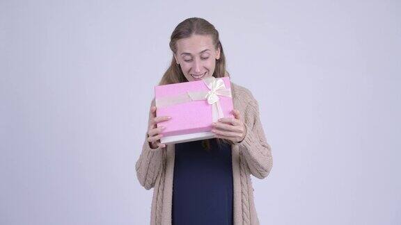 快乐的年轻金发孕妇拿着礼盒