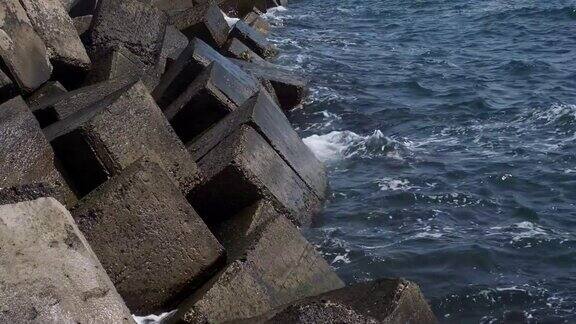 沿海混凝土防护结构破坏板块之间的大而深的裂缝保护海岸免受海浪冲击的侵蚀巨大的混凝土与钢筋保护海岸特写全高清-60fps