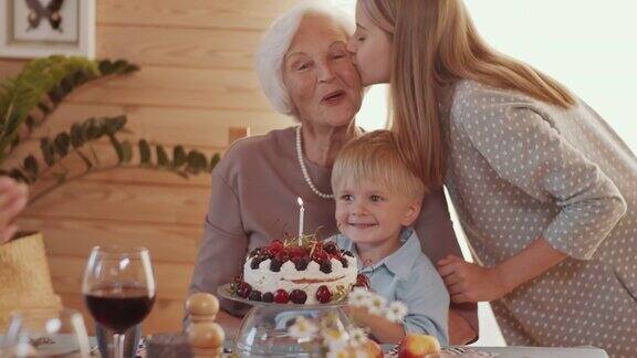 快乐的奶奶和孩子与家人庆祝生日