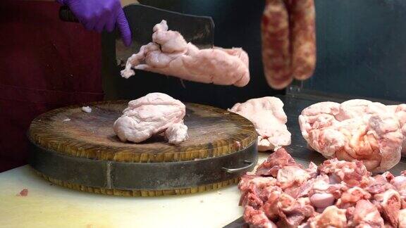 慢动作猪肉店老板用刀在木板上切生肉
