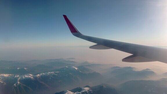 一架飞机的机翼飞过美丽的云层山脉