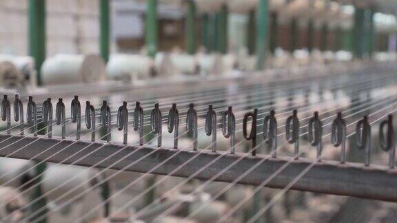 纺织厂工业整经机筒子架上的白色纱线轴