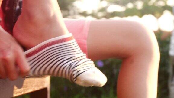 女孩穿着袜子前的滑板鞋在阳光明媚的早晨在公园里准备玩耍