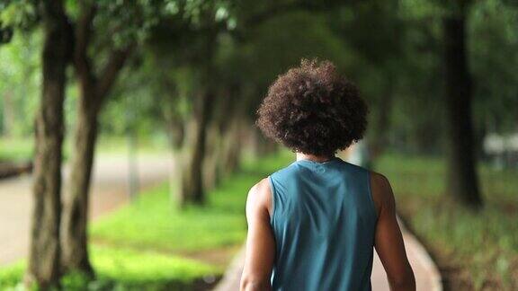 一个人走在城市公园的路上一个年轻黑人走在外面