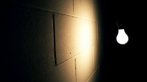 在黑暗的房间里灯泡靠墙摇摆