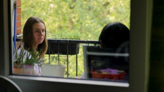 一个女人和她的朋友在阳台上喝咖啡聊天