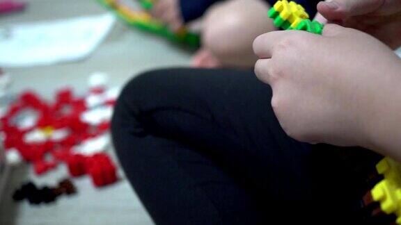 小孩子在室内玩许多五颜六色的塑料玩具主题在左边