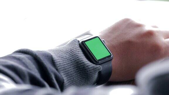 在咖啡厅使用绿色屏幕的触摸屏智能手表