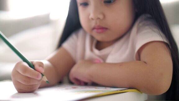 小女孩在家里的画册上写字慢镜头