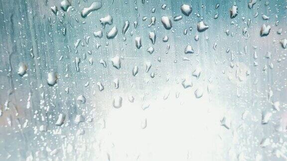 雨夜以红绿灯为背景的雨点打在车窗上