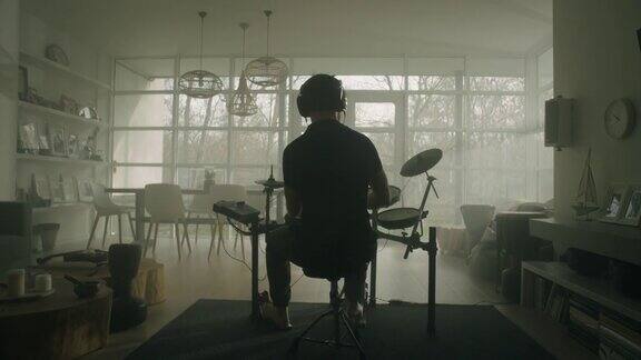 一个男人在他的客厅里练习电子鼓