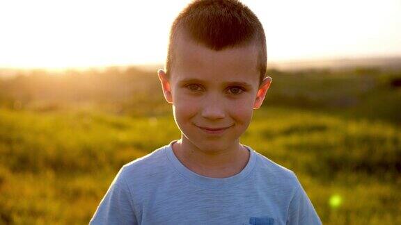 英俊的男孩在镜头前摆姿势的日落在野外