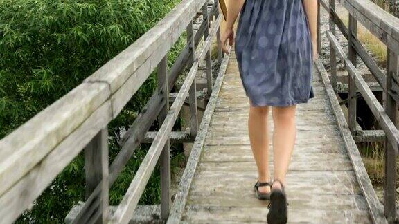 老妇人走在古老的木桥上