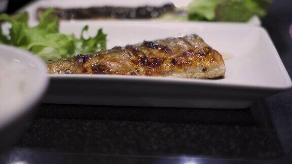 4k近距离烤鲭鱼在白色的菜日本食谱套餐菜单午餐时间亚洲菜家庭烹饪维生素omega3荧光灯黑色的桌子绿色蔬菜左图