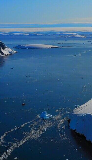 垂直视频南极海洋是雪山附近的孤独船只的背景