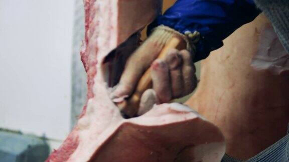 一名男性屠夫在工厂切肉