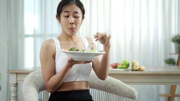 亚洲女性在家锻炼后吃健康沙拉