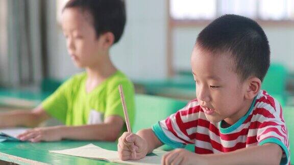 课堂上认真努力做笔记求知的小男孩