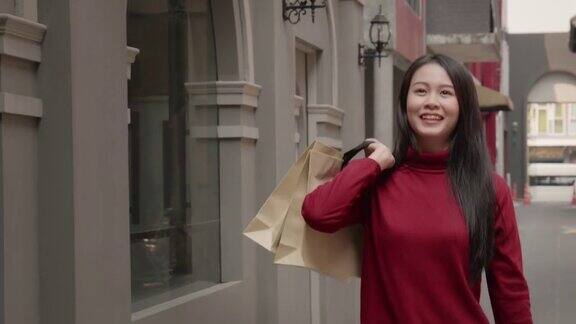 亚洲女性20-30岁拿着购物袋微笑着