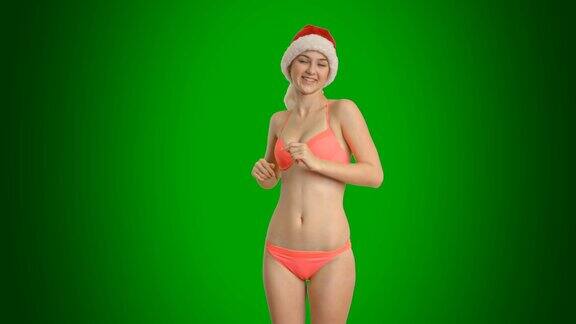 快乐的女孩穿着泳衣和帽子跳舞的圣诞老人