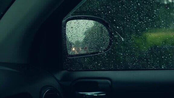 汽车在暴风雨中行驶司机POV侧镜透过窗户与雨点