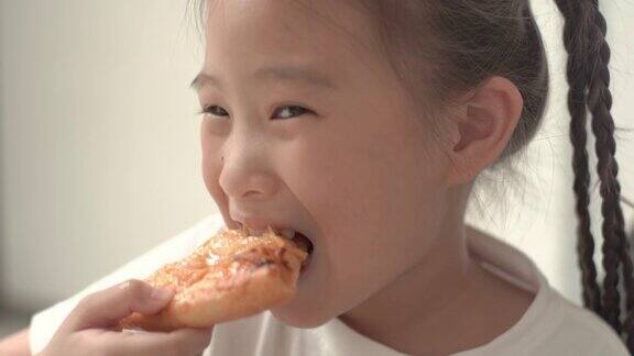 小女孩在家吃披萨的特写