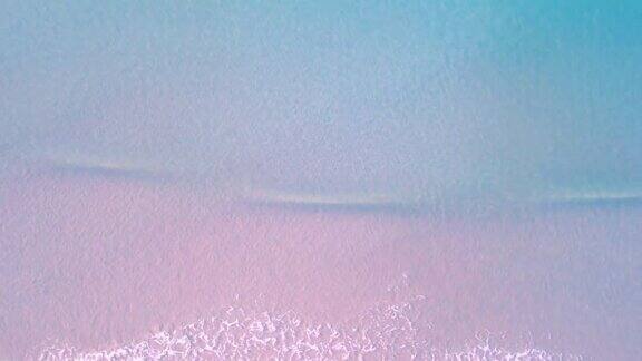 4K鸟瞰图无人机俯视图蓝色的海浪和美丽的粉色沙滩