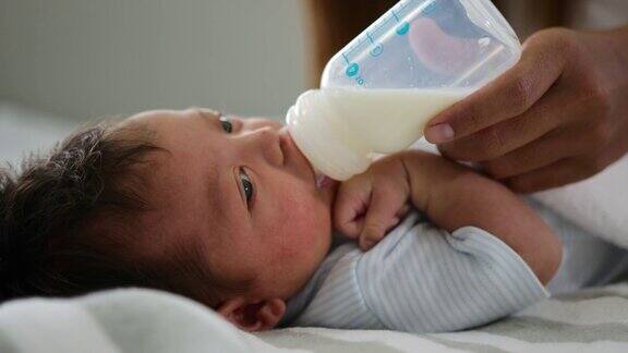 母亲在家里的卧室里给新生婴儿喂奶