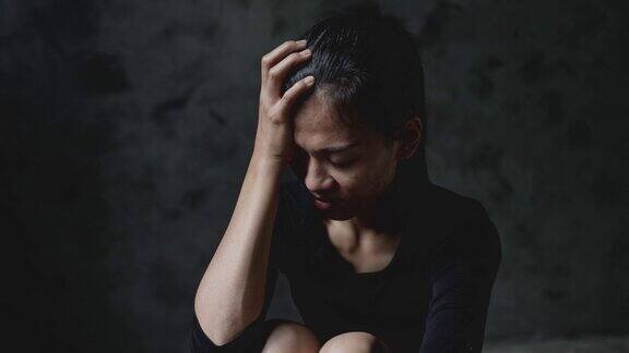 女人坐在黑暗中倾斜的慢动作家庭暴力家庭问题压力暴力抑郁和自杀