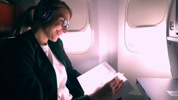 成功女乘客在飞机上使用蓝牙耳机进行降噪