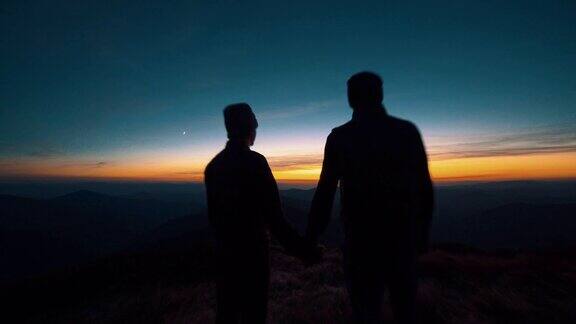这对夫妻站在夕阳背景下的山上