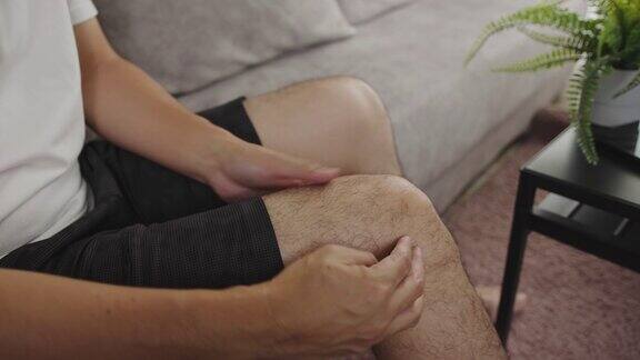 亚洲男人按摩他的膝盖疼痛和感觉不好触发点医疗保健概念