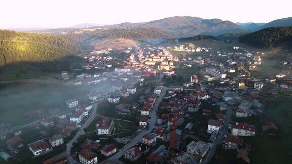 鸟瞰图的一个山村与晨雾在日出