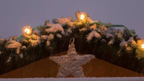 雪花下的露天市场摊位屋顶上的圣诞之星