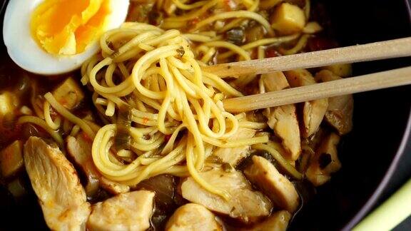 筷子在碗与鸡肉拉面汤